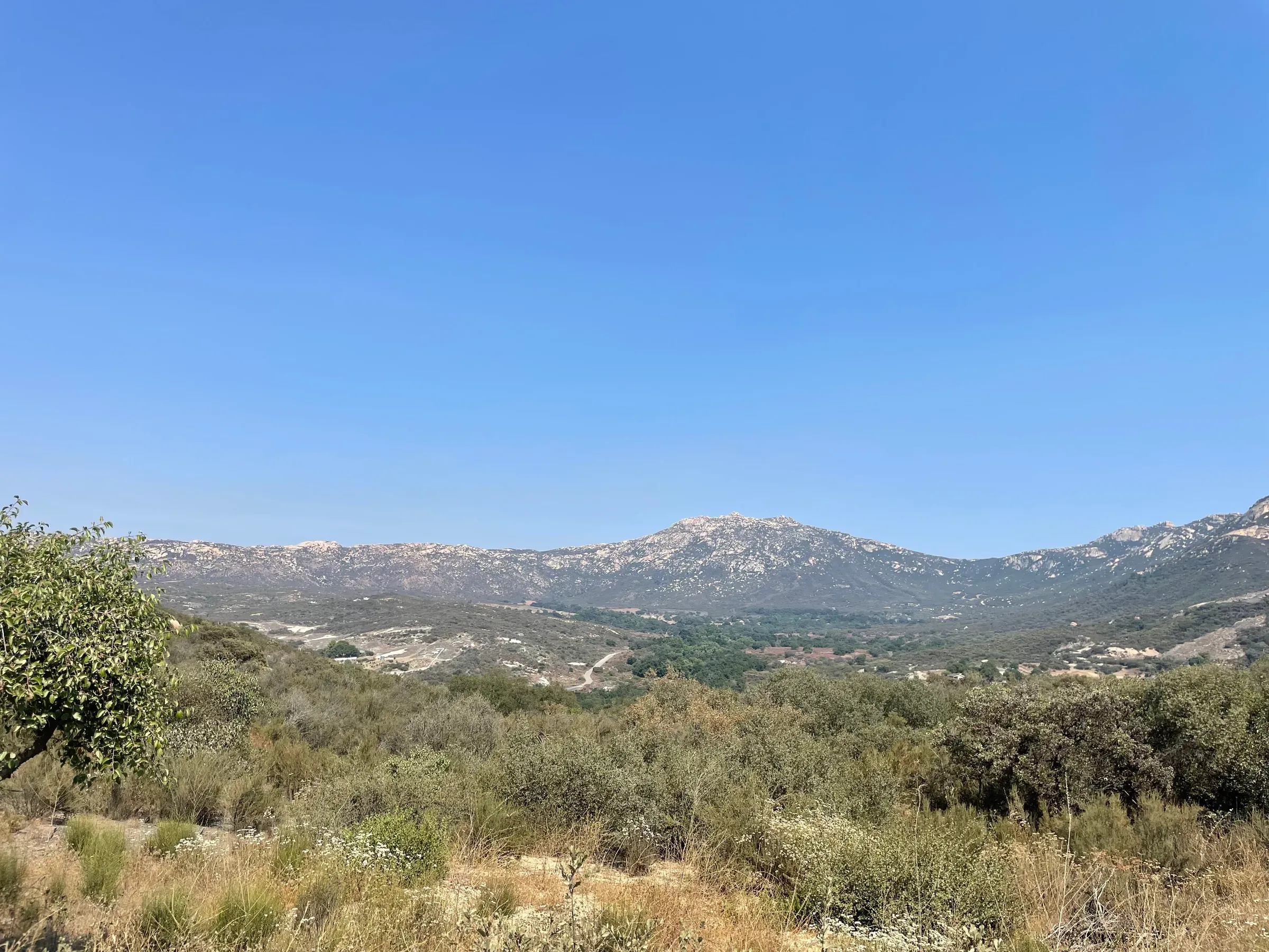 A wide valley view of chaparral-covered hills and mountains in Southern California